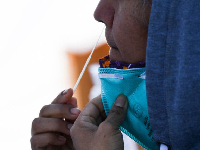 A person swabs their nose as part of a COVID-19 test