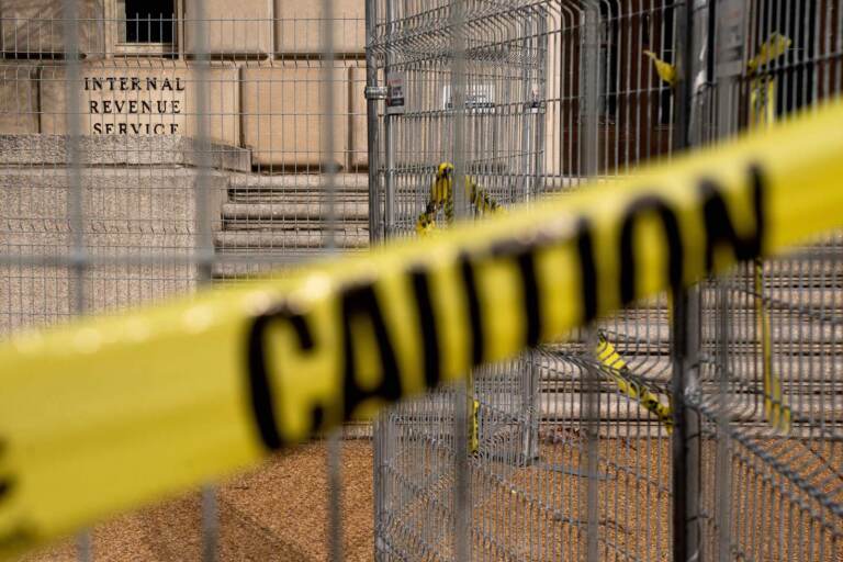 The outside of an IRS building, surrounded by caution tape.