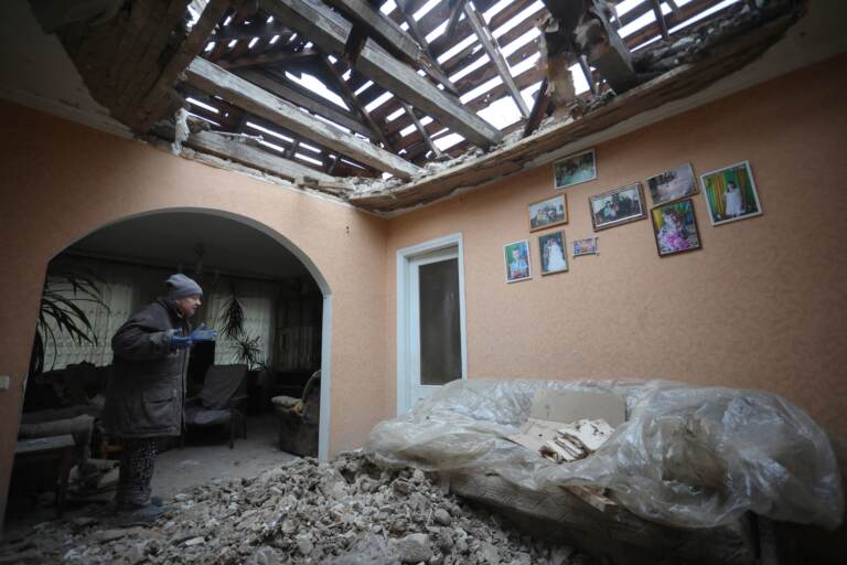 A local resident of the Ukrainian-controlled village of Stanytsia Luhanska, Luhansk region, gestures as she cleans up debris from her home after the shelling by Russia-backed separatists on February 18, 2022. (AlekseyFilippov/AFP via Getty Images)