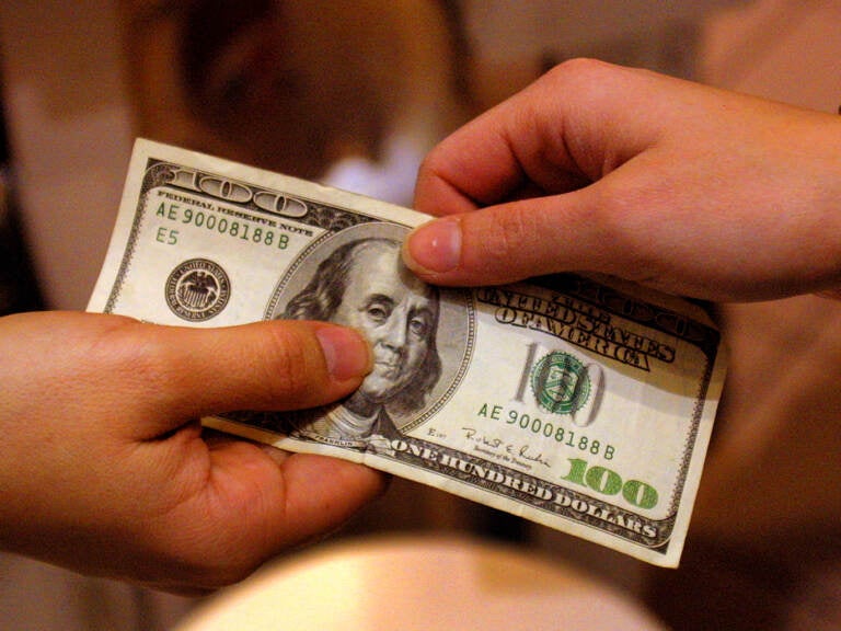 A shopper pays cash for sales merchandise on Dec. 26, 2000 in Austin, Texas. The Federal Reserve is considering whether to adopt a digital version of the dollar, in what would amount to a fundamental rethink of our national currency. (Joe Raedle/Getty Images)