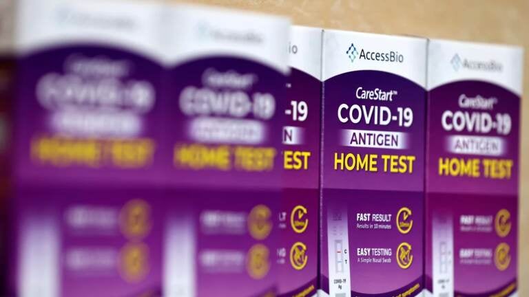 COVID-19 rapid at-home test kits rest on a table at a free distribution event for those who received vaccination shots or booster shots, at Union Station, on January 7, 2022 in Los Angeles, California.  (Photo by Mario Tama/Getty Images)