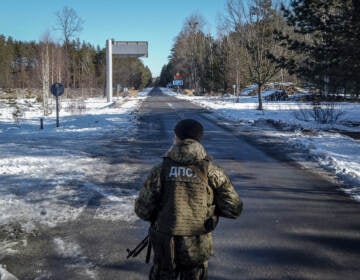 A member of the Ukrainian State Border Guard stands watch at the border crossing between Ukraine and Belarus on Saturday. (Chris McGrath/Getty Images)