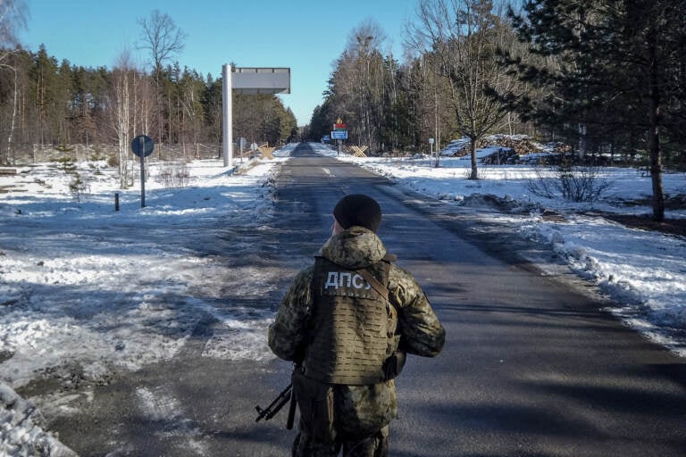 A member of the Ukrainian State Border Guard stands watch at the border crossing between Ukraine and Belarus on Saturday. (Chris McGrath/Getty Images)