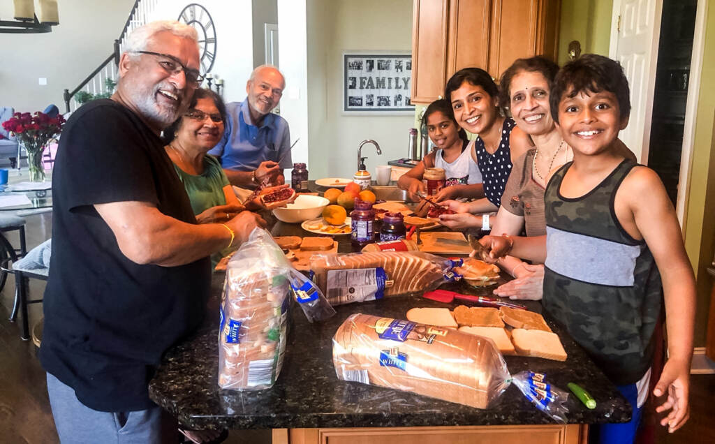 A group of volunteers for the "Bread Drop" making peanut butter and jelly sandwiches in their home