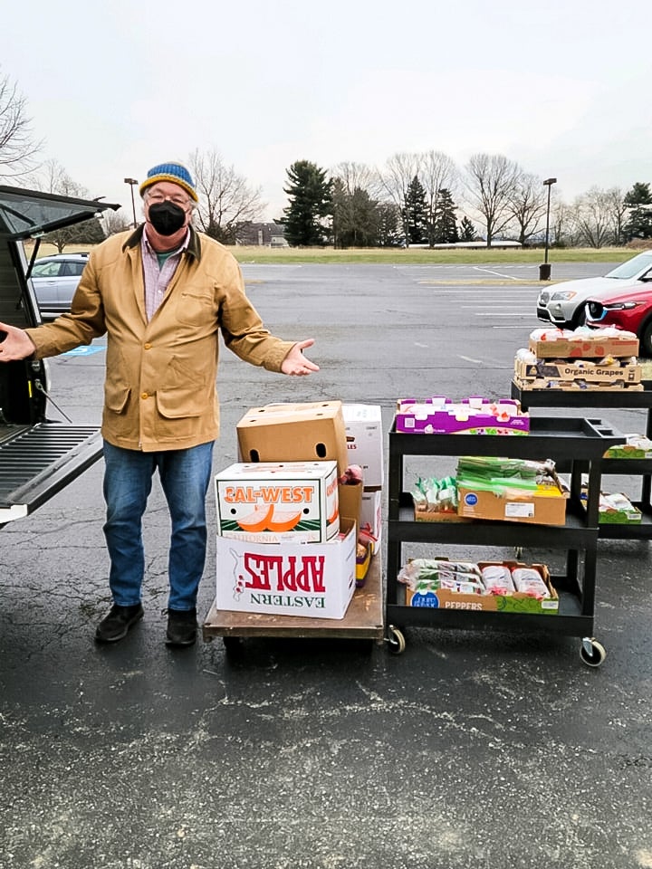 Lou Farrell outside loading peanut butter and jelly sandwiches into his car