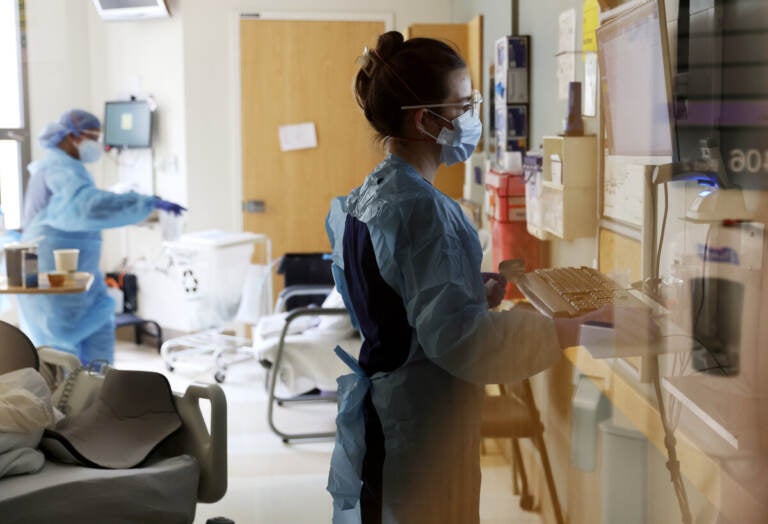 Nurse Elisa Gilbert checks on a patient in the acute care COVID-19 unit