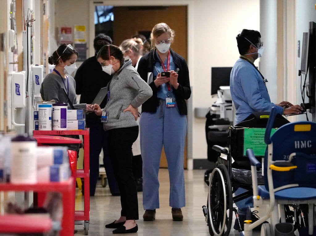 Medical workers fill a hallway in the acute care unit