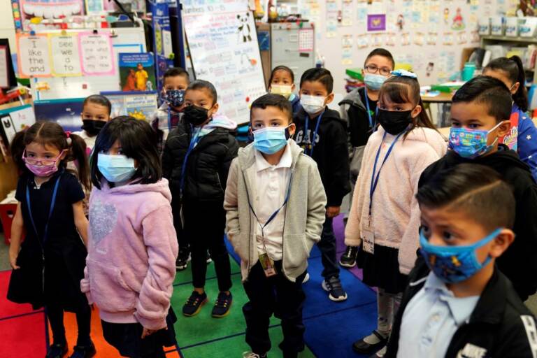 Kindergarteners wear masks while listening to their teacher amid the COVID-19 pandemic at Washington Elementary School Wednesday, Jan. 12, 2022 (AP Photo/Marcio Jose Sanchez)