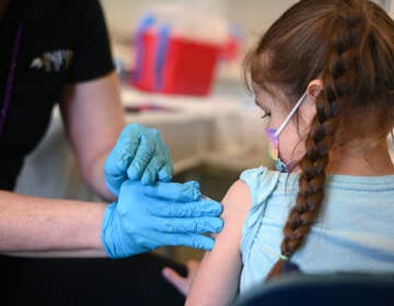 A nurse administers a pediatric dose of the COVID-19 vaccine
