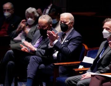 President Joe Biden and others clap while seated at the National Prayer Breakfast