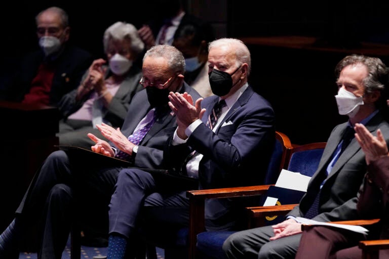 President Joe Biden and others clap while seated at the National Prayer Breakfast