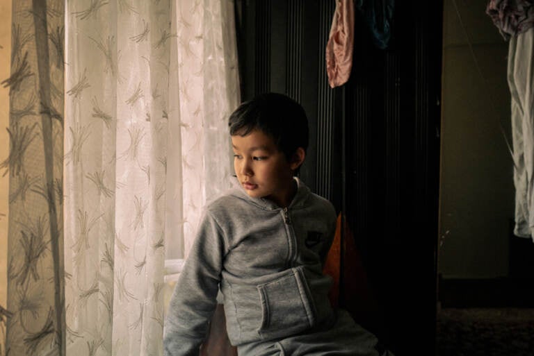 Lütfullah Kuçar, 8, waits at home for his sister, Aysu Kuçar, to return from school, in Istanbul. The two Uyghur children were forcibly separated from their family and spent nearly 20 months in state boarding schools in Xinjiang, China. Lütfullah Kuçar is seen inside his home