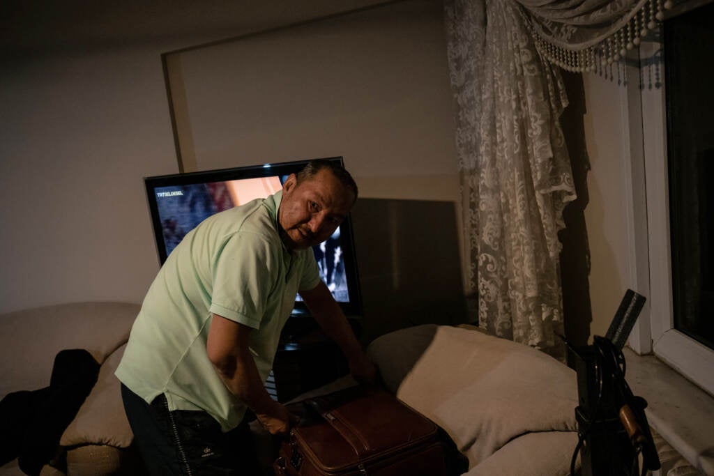 Abdüllatif Kuçar looks through a suitcase