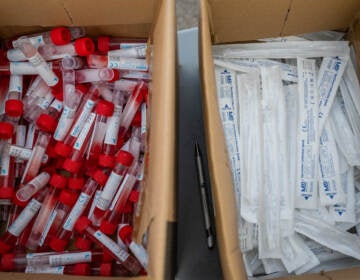 Vials of testing fluid and packages of nose swabs are seen at a drive through COVID-19 testing site