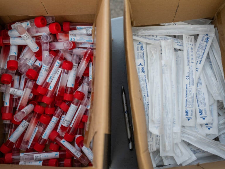 Vials of testing fluid and packages of nose swabs are seen at a drive through COVID-19 testing site