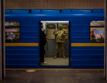 A Ukrainian army officer looks at his phone in a local train