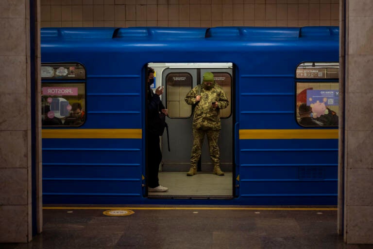 A Ukrainian army officer looks at his phone in a local train