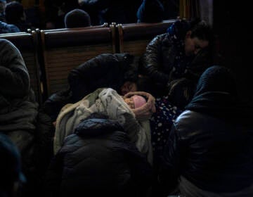 A baby is seen sleeping inside Lviv railway station