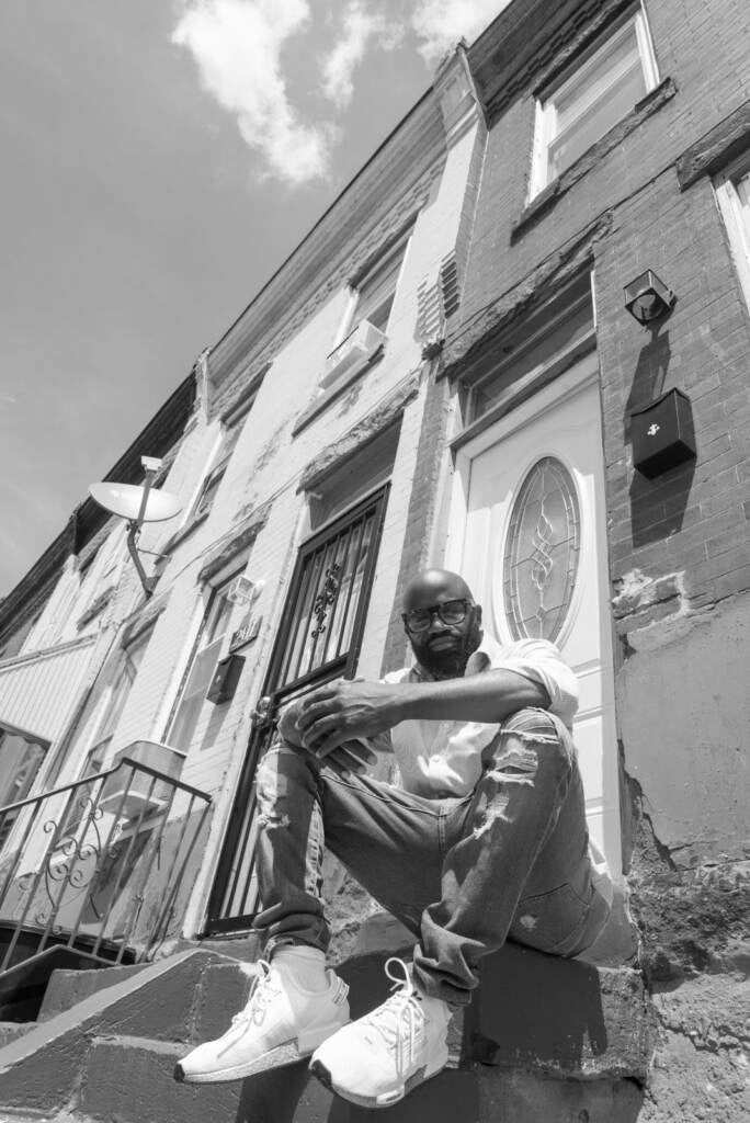 Sadiq Sellers is seen sitting on a stoop in Philly