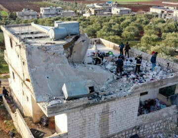 People inspect a destroyed house following an operation by the U.S. military in the Syrian village of Atmeh