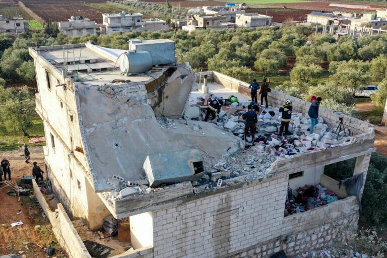 People inspect a destroyed house following an operation by the U.S. military in the Syrian village of Atmeh