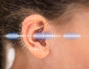 A human ear overlaid with a graphic representing hearing and sound