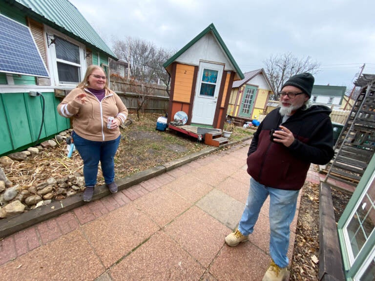 Gene Cox speaks with Brenda Konkel, president of Occupy Madison and executive director of Madison Area Care for the Homeless OneHealth. Occupy Madison provides tiny houses for people experiencing homelessness in Madison, Wisconsin. (Giles Bruce for KHN)