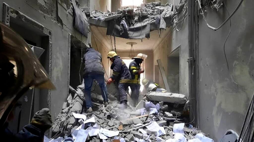 Emergency service personnel inspecting the damage inside the City Hall building in Kharkiv