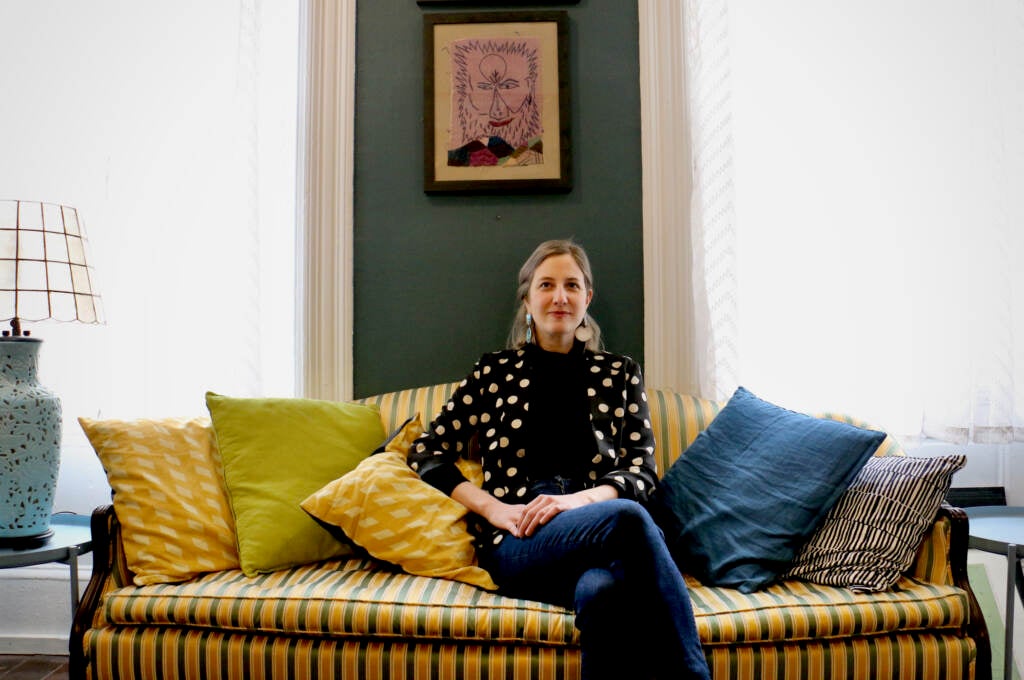 Emily Smith poses for a portrait on a couch