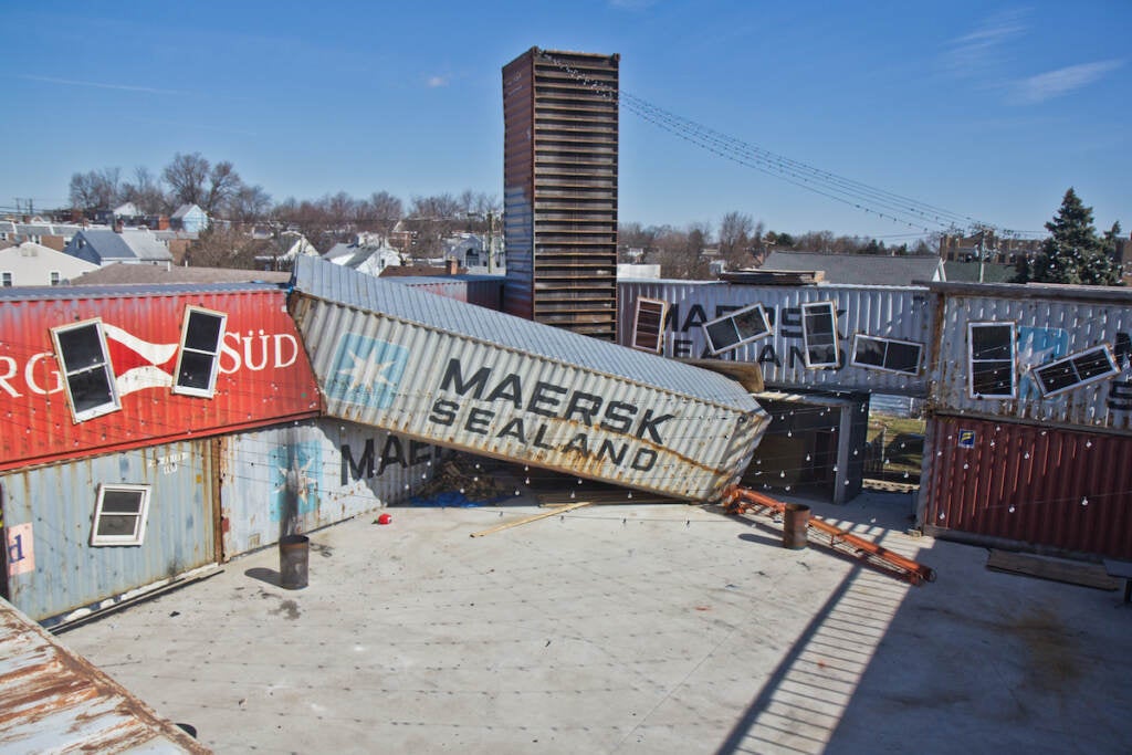 Shipping containers are arranged haphazardly on an open lot.