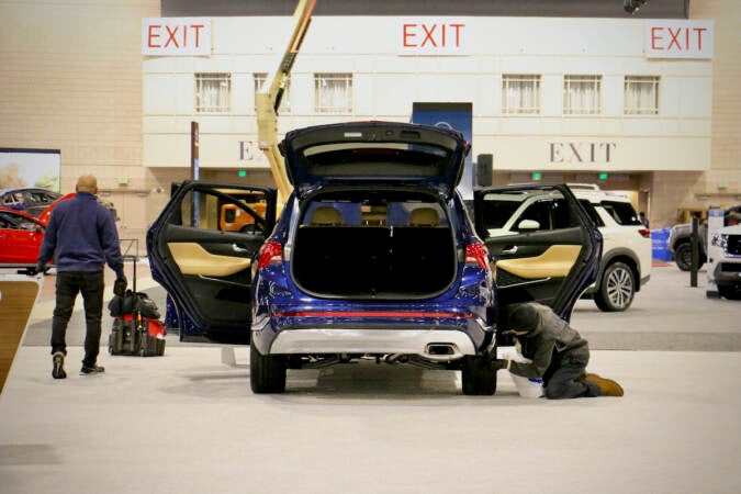 Workers prepare cars for the 2022 Philadelphia Auto Show