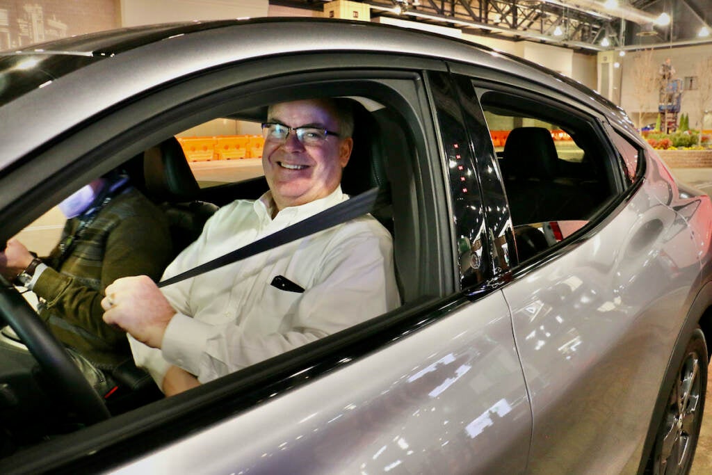 Rich Terrell buckles up for a ride in an electric vehicle