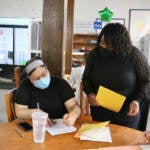 Former Philadelphia Poet Laureate Trapeta Mayson works with Amaryllis Ruiz durijg a poetry workshop at the Open Door Clubhouse in Kensington