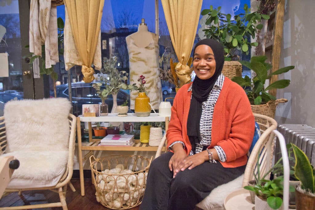 Melanie Hasan sits inside her shop, Modest Transitions