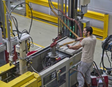 A technician is working on a machine in a factory