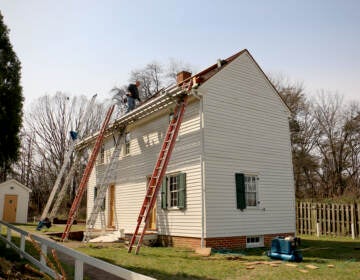 Roofers make repairs to the historic Peter Mott House in Lawnside, N.J.  The home was a station along the Underground Railroad and serves as a museum and home to the Lawnside Historical Society. (Emma Lee/WHYY)