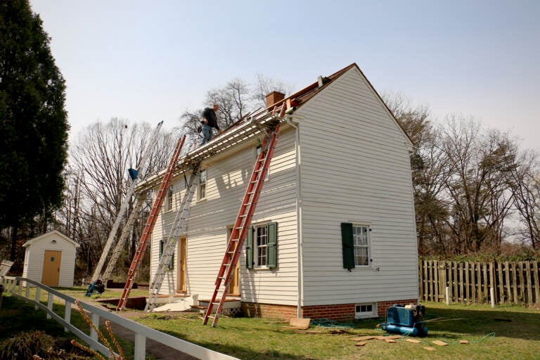 Roofers make repairs to the historic Peter Mott House in Lawnside, N.J.  The home was a station along the Underground Railroad and serves as a museum and home to the Lawnside Historical Society. (Emma Lee/WHYY)