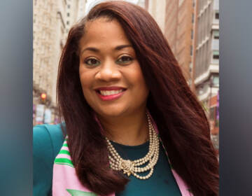 Gail Carter-Hamilton smiles, wearing a pink and green scarf and necklace.