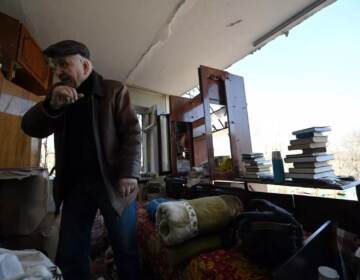 A local resident collects the belongings out of his apartment in Kyiv on Sunday in a five-story residential building that partially collapsed after a shelling by Russian troops. (Sergei Supinsky/AFP via Getty Images)