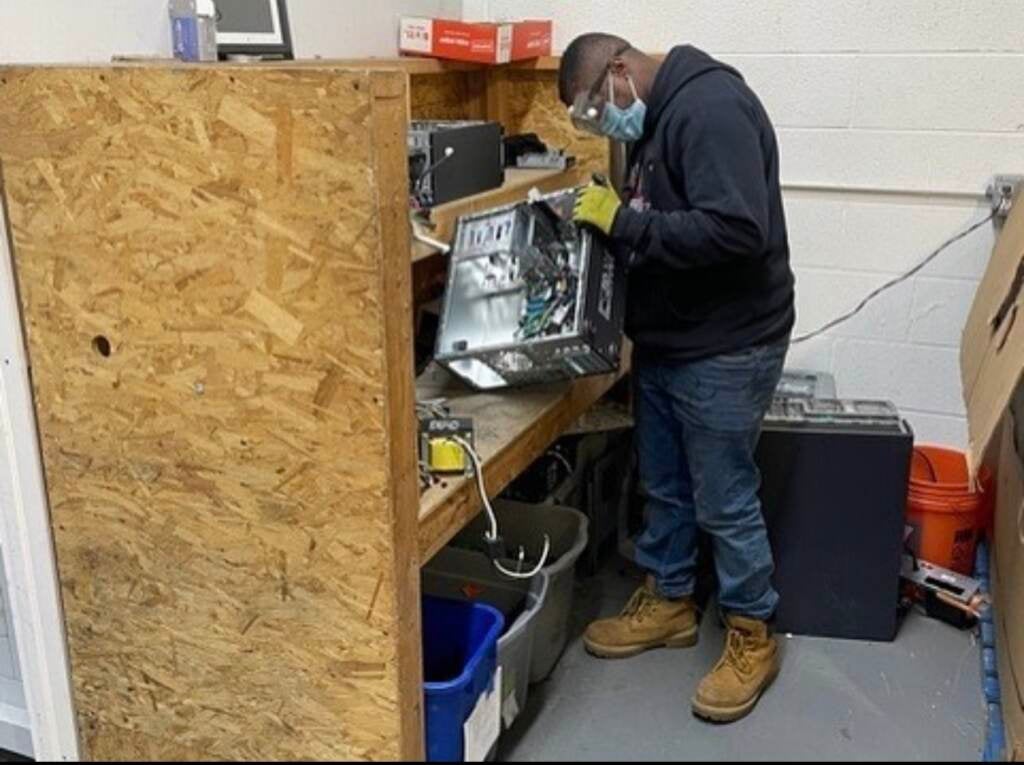 A PAR-Recycle employee examines one of the pieces of e-waste that the nonprofit collects and recycles.