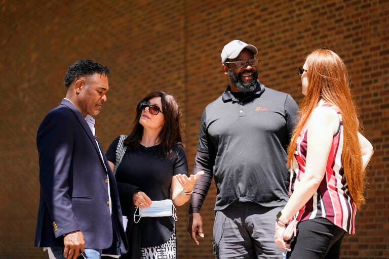 File photo: (From left) former NFL player Ken Jenkins and his wife Amy Lewis, along with former NFL player Clarence Vaughn III and his wife Brooke Vaughn, meet before delivering tens of thousands of petitions demanding equal treatment for everyone involved in the settlement of concussion claims against the NFL, to the federal courthouse in Philadelphia, Friday, May 14, 2021.  (AP Photo/Matt Rourke)