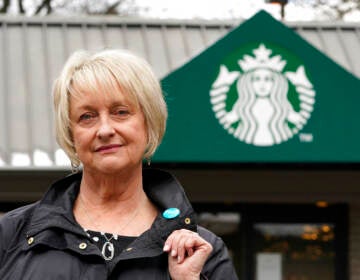 Pam Blauman-Schmitz, who was a union rep at Starbucks in the mid-1980's, poses for a photo in front of a Starbucks coffee shop Tuesday, Feb. 22, 2022, in Seattle.