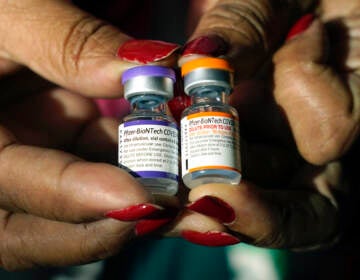 Jackson-Hinds Comprehensive Health Center nurse Maggie Bass holds a vial of the Pfizer COVID-19 vaccine