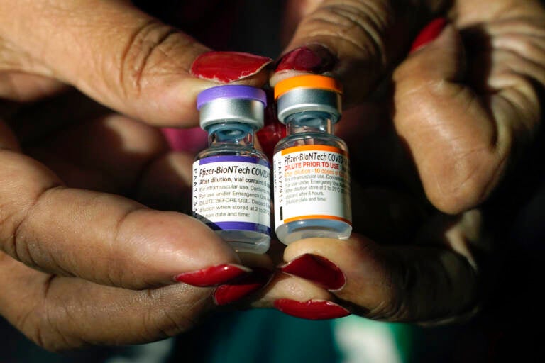 Jackson-Hinds Comprehensive Health Center nurse Maggie Bass holds a vial of the Pfizer COVID-19 vaccine