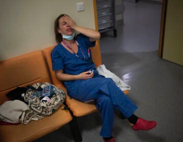 FILE - Nurse Marie-Laure Satta pauses during her New Year's Eve shift in the COVID-19 intensive care unit at the la Timone hospital in Marseille, southern France, Friday, Dec. 31, 2021. The official global death toll from COVID-19 is on the verge of eclipsing 6 million — underscoring that the pandemic, now in its third year, is far from over. (AP Photo/Daniel Cole, File)