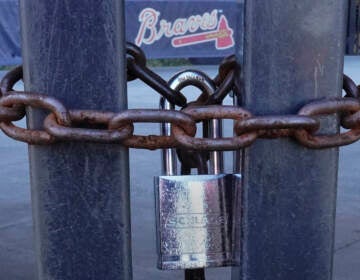 Locked gates are shown at Truist Park, home of the Atlanta Braves baseball team, Wednesday, March 2, 2022, in Atlanta. With owners and players unable to agree on a labor contract to replace the collective bargaining agreement that expired Dec. 1, baseball commissioner Rob Manfred followed through with his threat on Tuesday and canceled the first two series for each of the 30 major league teams. (AP Photo/John Bazemore)