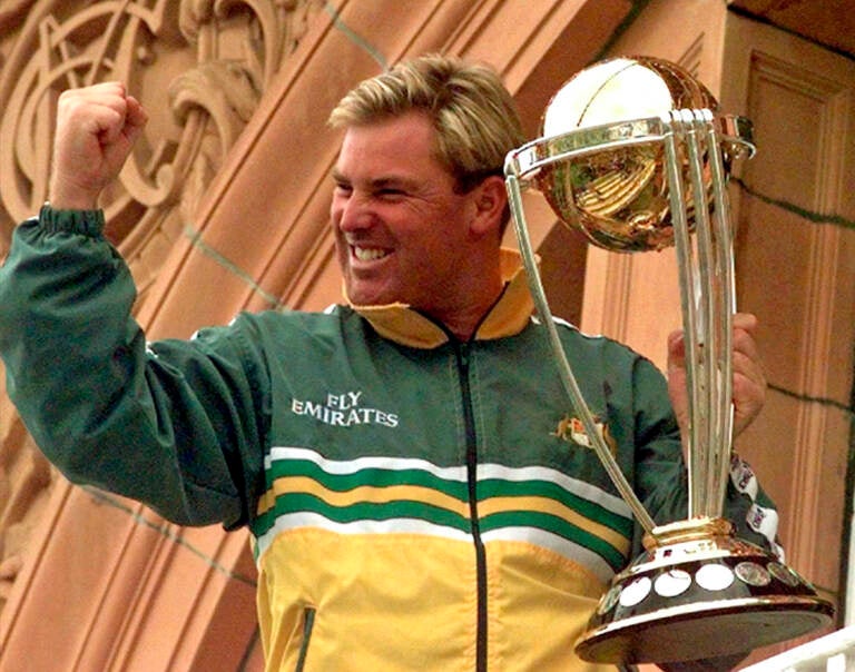 File photo: Australia's Shane Warne clenches his fist as he holds the Cricket World Cup Trophy on the team balcony at Lords after Australia defeated Pakistan by 8 wickets in the final of the Cricket World Cup, in London Sunday, June 20, 1999. Shane Warne, one of the greatest cricket players in history, has died. He was 52. (AP Photo/Rui Vieira, File)