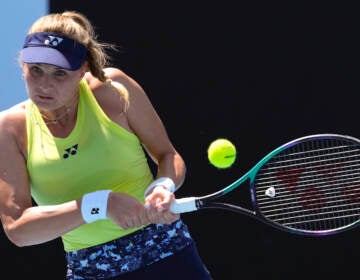 Dayana Yastremska of Ukraine plays a backhand return to Madison Brengle of the U.S. during their first round match at the Australian Open tennis championships in Melbourne, Australia, Monday, Jan. 17, 2022. (AP Photo/Simon Baker)