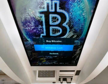 A Bitcoin logo appears on the display screen of a cryptocurrency ATM at the Smoker's Choice store in Salem, N.H. President Joe Biden is signing an executive order on government oversight of cryptocurrency that urges the Federal Reserve to explore whether the central bank should create its own digital currency