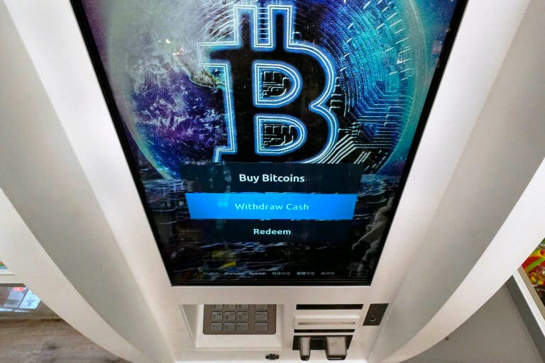 A Bitcoin logo appears on the display screen of a cryptocurrency ATM at the Smoker's Choice store in Salem, N.H. President Joe Biden is signing an executive order on government oversight of cryptocurrency that urges the Federal Reserve to explore whether the central bank should create its own digital currency